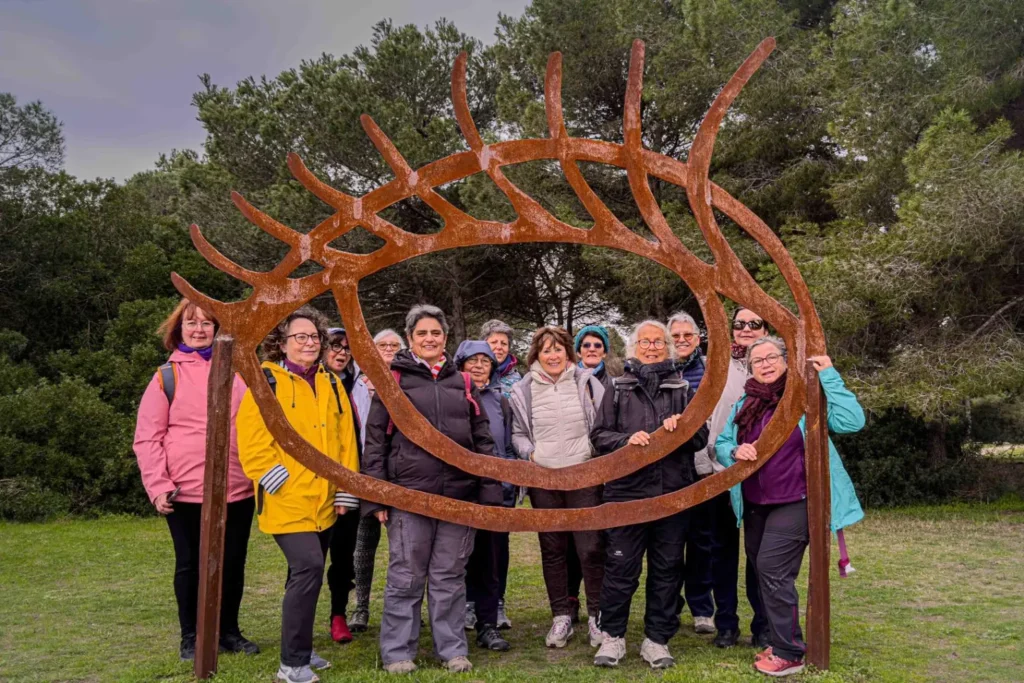 Les adhérents de Connaissance & Partage réunis à l'intérieur d'une sculpture en acier lors d'une sortie en bord de mer